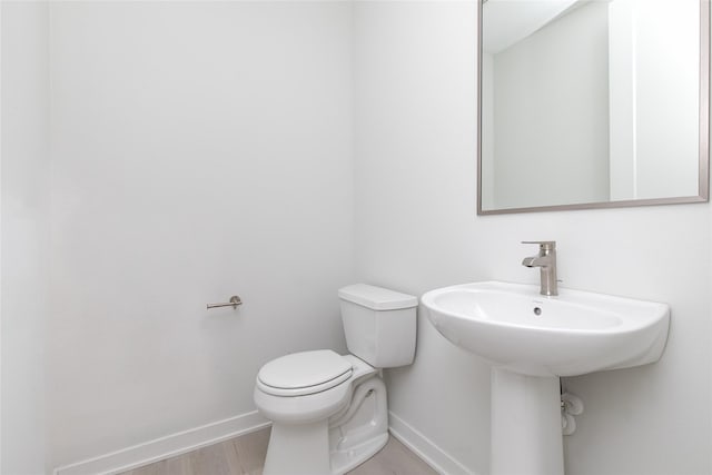 225 Maple St, Des Moines, IA 50309 - bathroom featuring toilet, wood finished floors, and baseboards