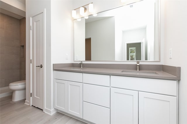225 Maple St, Des Moines, IA 50309 - full bath with a sink, toilet, double vanity, and wood finished floors