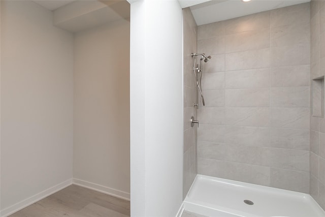 225 Maple St, Des Moines, IA 50309 - full bath with baseboards, tiled shower, and wood finished floors