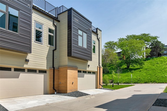 225 Maple St, Des Moines, IA 50309 - view of property exterior with a garage, concrete driveway, and brick siding