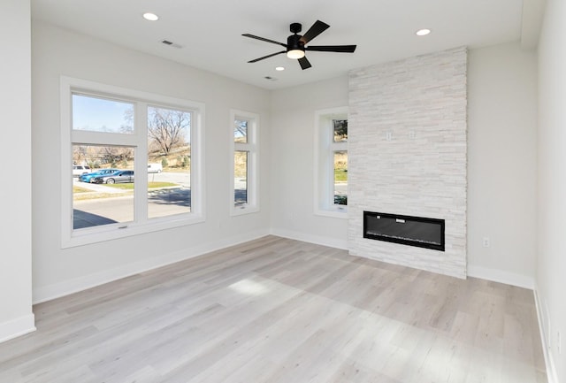 225 Maple St, Des Moines, IA 50309 - unfurnished living room with a ceiling fan, visible vents, a large fireplace, and light wood-style floors