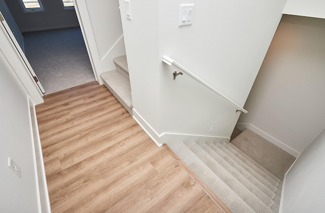 stairs with wood finished floors and baseboards