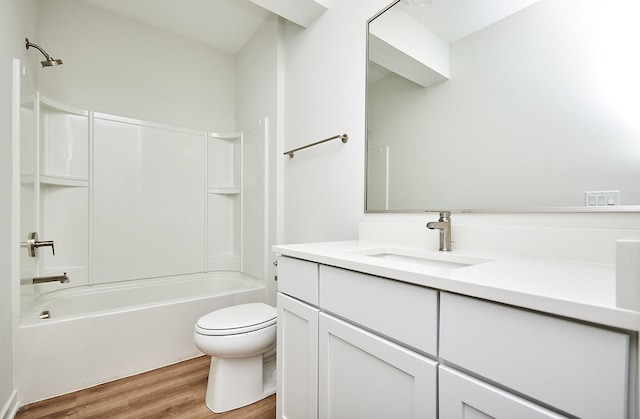 bathroom with toilet, wood finished floors, vanity, and shower / bathing tub combination
