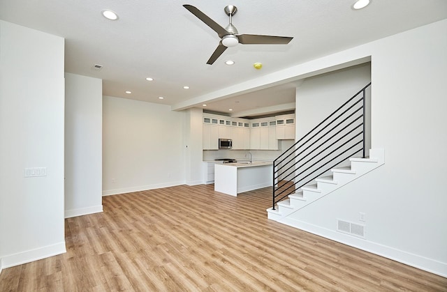 unfurnished living room featuring recessed lighting, light wood-style flooring, stairs, visible vents, and ceiling fan