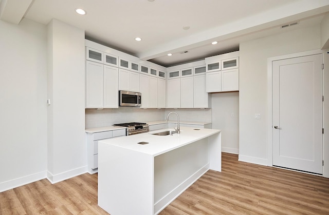 kitchen with tasteful backsplash, light wood-style flooring, visible vents, stainless steel appliances, and a sink