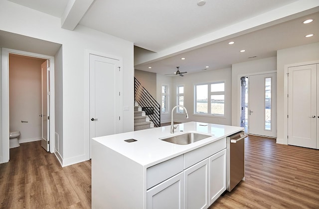kitchen with recessed lighting, light countertops, stainless steel dishwasher, light wood finished floors, and a sink