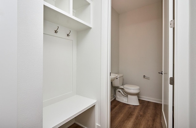 mudroom featuring baseboards and dark wood-style floors