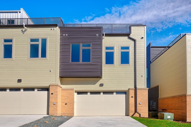 exterior space with brick siding, an attached garage, and driveway