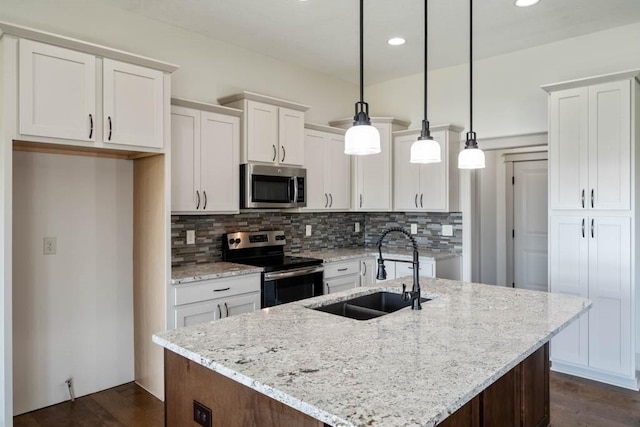 2102 NW 24th St, Ankeny, IA 50023 - kitchen with appliances with stainless steel finishes, white cabinetry, tasteful backsplash, a center island with sink, and dark wood finished floors