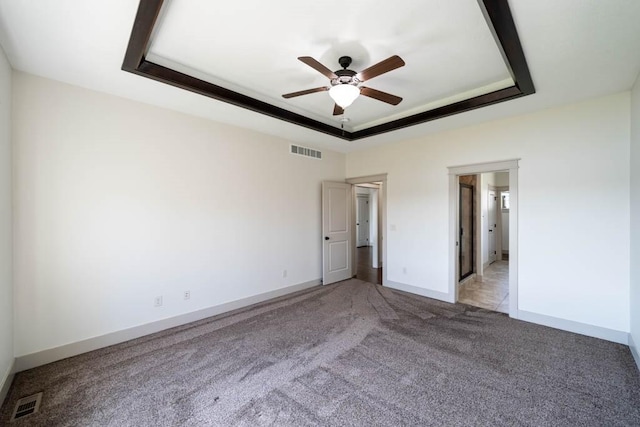 2102 NW 24th St, Ankeny, IA 50023 - unfurnished bedroom with a raised ceiling, light colored carpet, and a ceiling fan