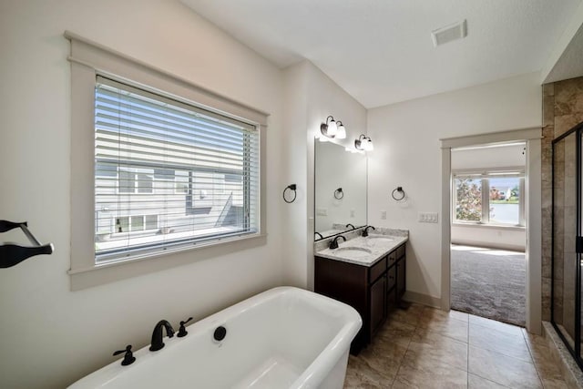 2102 NW 24th St, Ankeny, IA 50023 - bathroom featuring a freestanding tub, double vanity, a stall shower, and tile patterned floors