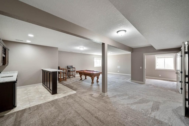 2102 NW 24th St, Ankeny, IA 50023 - basement featuring light colored carpet, billiards, plenty of natural light, and a textured ceiling