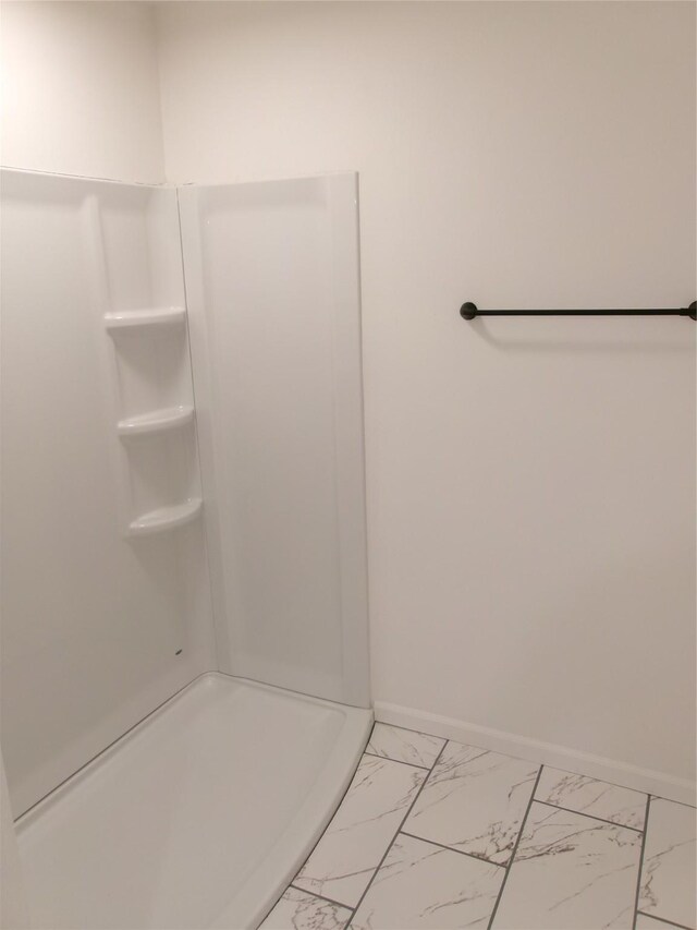 408 5th St, Menlo, IA 50164 - full bathroom featuring marble look tiles, baseboards, and a shower