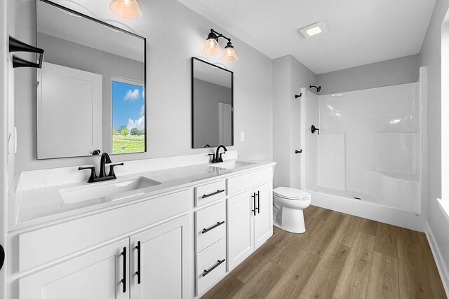 320 Veterans Blvd, Knoxville, IA 50138 - bathroom featuring wood finished floors, a shower, and double vanity