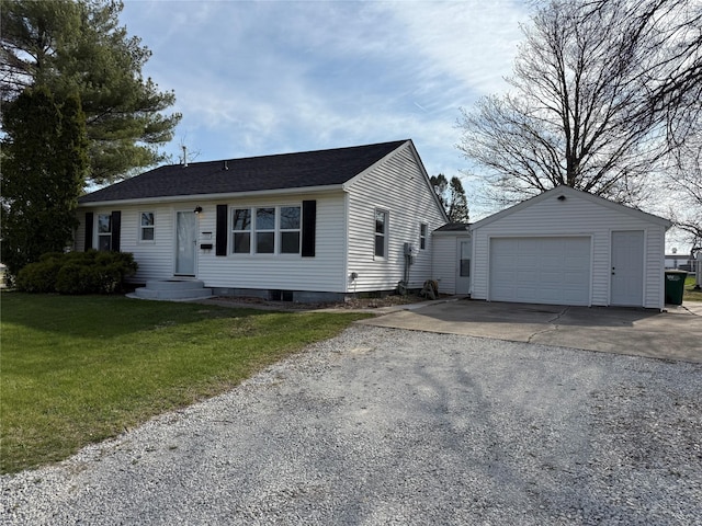 view of front of home with a front yard, driveway, an outdoor structure, and a detached garage