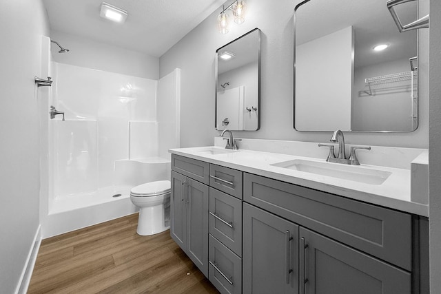 324 Veterans Blvd, Knoxville, IA 50138 - full bathroom with wood finished floors, double vanity, and a shower