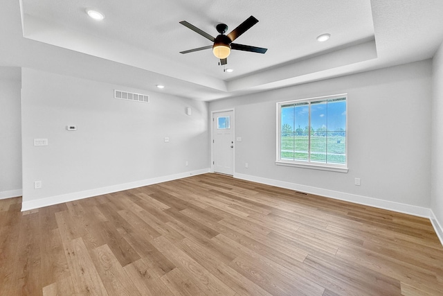 324 Veterans Blvd, Knoxville, IA 50138 - unfurnished room featuring a raised ceiling, ceiling fan, light wood finished floors, and recessed lighting