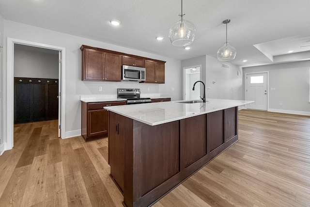 324 Veterans Blvd, Knoxville, IA 50138 - kitchen featuring stainless steel appliances, light wood-style flooring, a kitchen island with sink, pendant lighting, and recessed lighting