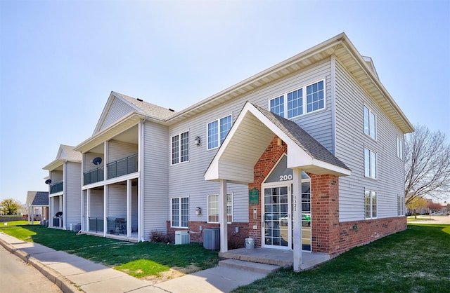 1325 SE Florence Dr Unit 211, Waukee, IA 50263 - back of property with brick siding, central AC, and a yard