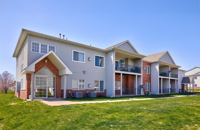 1325 SE Florence Dr Unit 211, Waukee, IA 50263 - rear view of property with brick siding, central AC, and a lawn