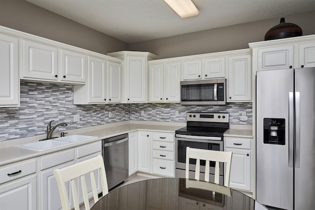 1325 SE Florence Dr Unit 211, Waukee, IA 50263 - kitchen with a sink, backsplash, white cabinets, and appliances with stainless steel finishes