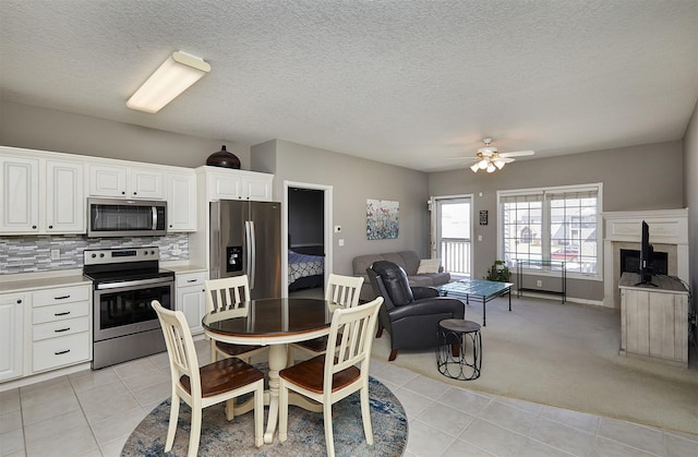1325 SE Florence Dr Unit 211, Waukee, IA 50263 - dining room featuring light carpet, a textured ceiling, a ceiling fan, and light tile patterned flooring
