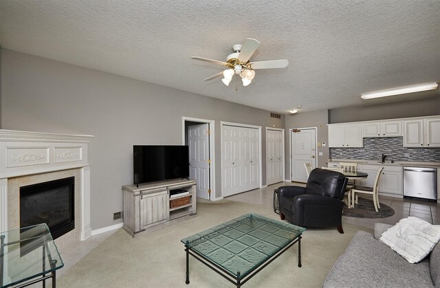 1325 SE Florence Dr Unit 211, Waukee, IA 50263 - living area featuring visible vents, a ceiling fan, a textured ceiling, a fireplace, and light colored carpet