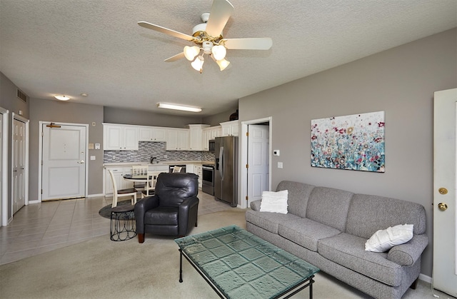 1325 SE Florence Dr Unit 211, Waukee, IA 50263 - living area with visible vents, baseboards, ceiling fan, a textured ceiling, and light carpet