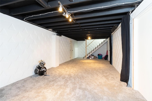 finished below grade area featuring stairs and carpet floors