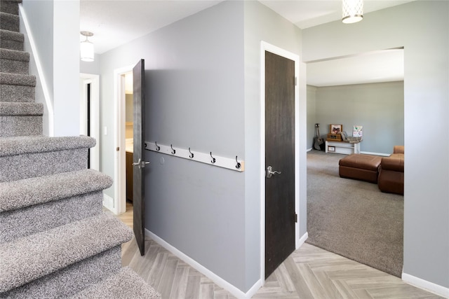 stairway with baseboards and carpet