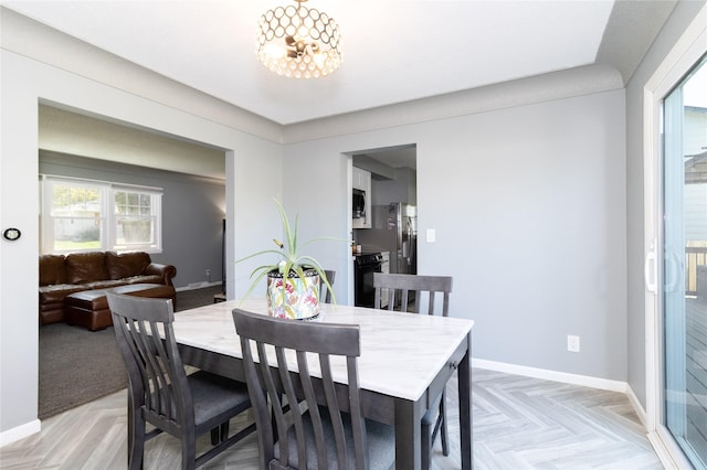 dining area with baseboards and an inviting chandelier