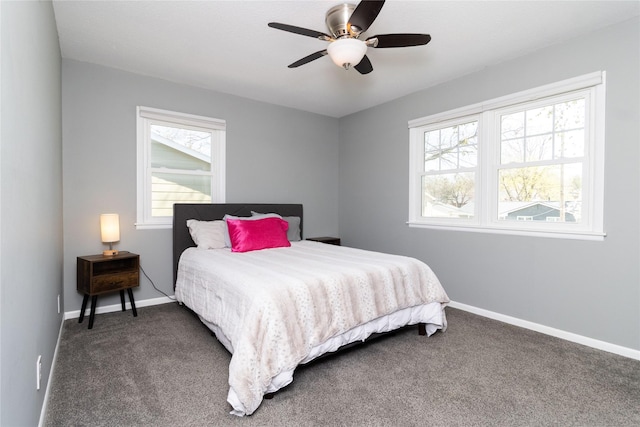 carpeted bedroom with multiple windows, baseboards, and a ceiling fan