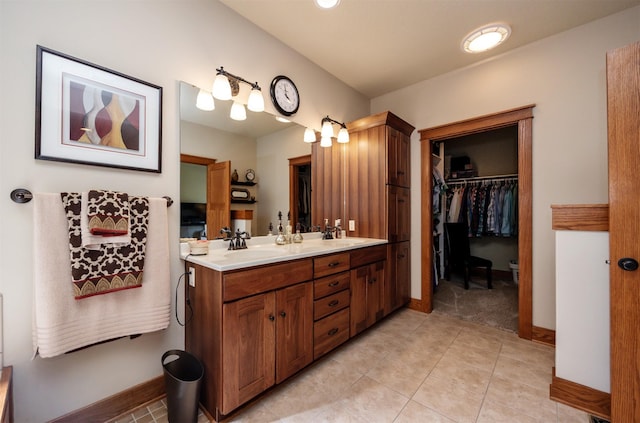 5570 Sunburst Dr, Pleasant Hill, IA 50327 - full bath with baseboards, double vanity, a spacious closet, tile patterned flooring, and a sink