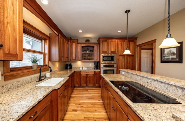 5570 Sunburst Dr, Pleasant Hill, IA 50327 - kitchen featuring a sink, brown cabinetry, appliances with stainless steel finishes, and light wood finished floors
