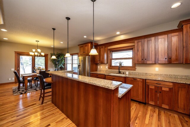 5570 Sunburst Dr, Pleasant Hill, IA 50327 - kitchen featuring a sink, light wood-style flooring, recessed lighting, and stainless steel fridge