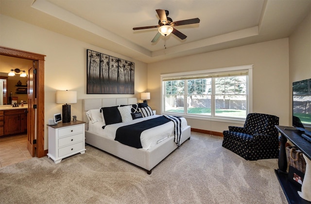 5570 Sunburst Dr, Pleasant Hill, IA 50327 - bedroom featuring baseboards, a raised ceiling, a sink, ensuite bath, and light colored carpet