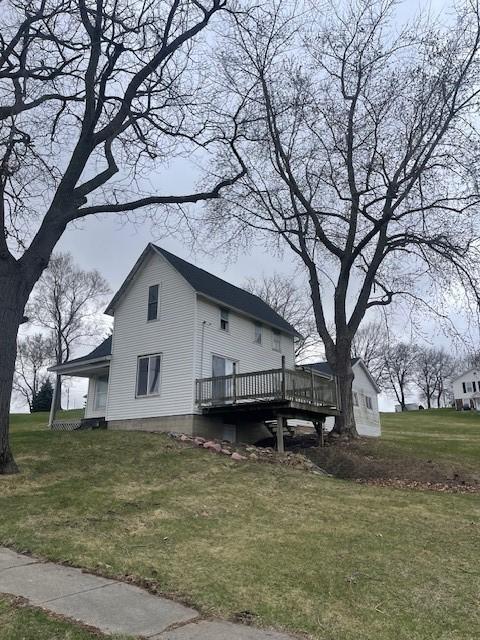view of home's exterior featuring a wooden deck and a lawn