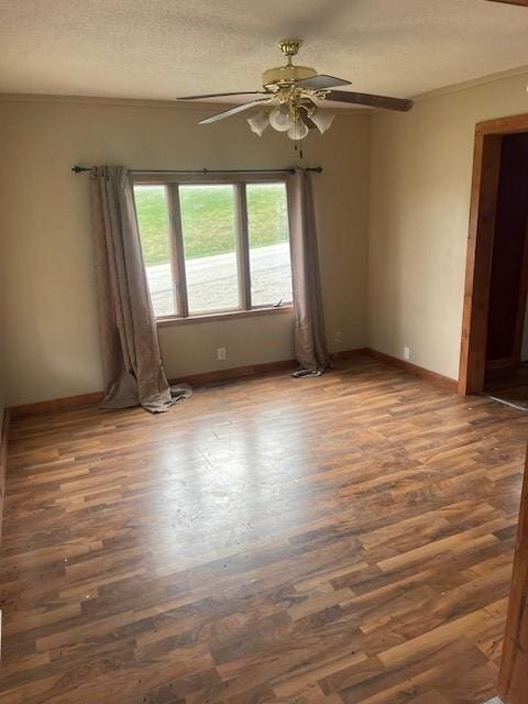 unfurnished room featuring ceiling fan, wood finished floors, baseboards, and a textured ceiling