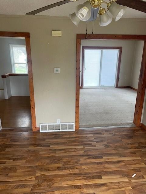 spare room featuring visible vents, baseboards, wood finished floors, and ceiling fan