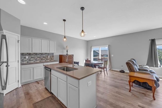 1106 E 28th St, Norwalk, IA 50211 - kitchen with healthy amount of natural light, stainless steel dishwasher, decorative backsplash, white cabinets, and recessed lighting