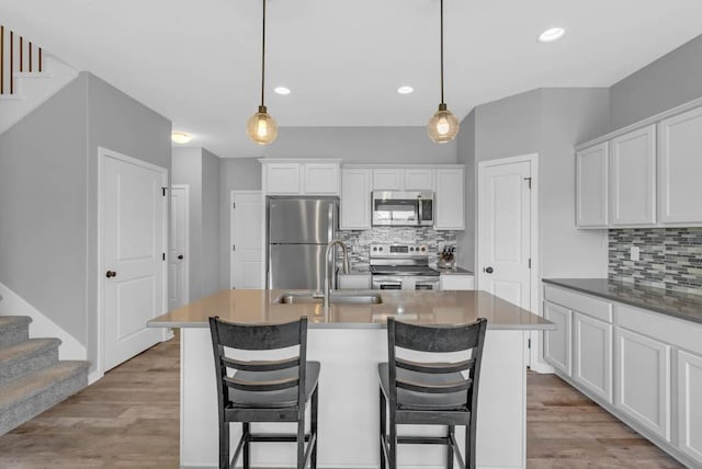1106 E 28th St, Norwalk, IA 50211 - kitchen with stainless steel appliances, backsplash, light wood finished floors, and recessed lighting