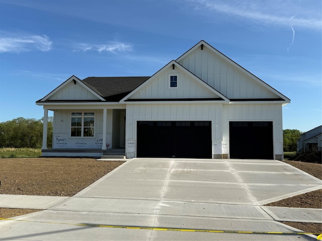 modern farmhouse with an attached garage, driveway, covered porch, board and batten siding, and roof with shingles
