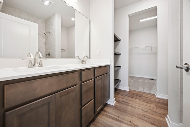 1609 Garland Ave, Norwalk, IA 50021 - full bathroom with wood finished floors, double vanity, a spacious closet, and a shower