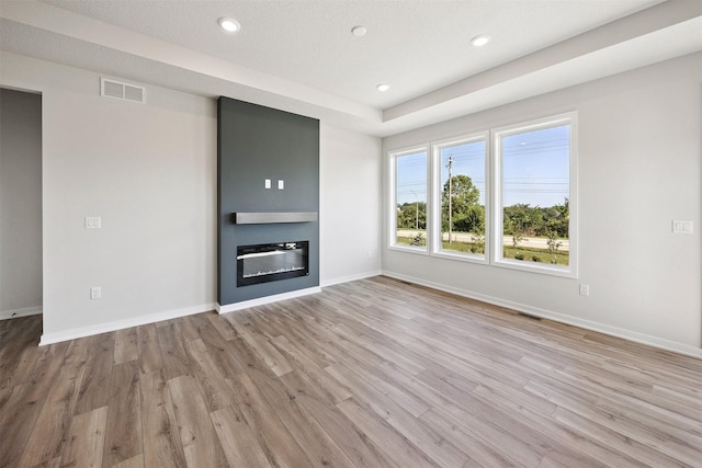 1609 Garland Ave, Norwalk, IA 50021 - unfurnished living room featuring wood finished floors, a glass covered fireplace, and recessed lighting