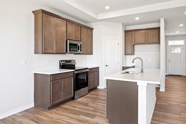 1609 Garland Ave, Norwalk, IA 50021 - kitchen featuring stainless steel appliances, light wood-style floors, tasteful backsplash, and recessed lighting