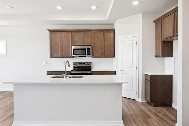 1609 Garland Ave, Norwalk, IA 50021 - kitchen with appliances with stainless steel finishes, light wood-style floors, backsplash, light countertops, and recessed lighting