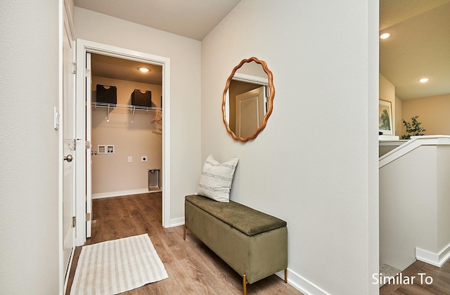 hall featuring an upstairs landing, baseboards, wood finished floors, and recessed lighting
