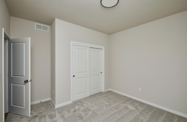 1139 NW Petersen Dr, Waukee, IA 50263 - unfurnished bedroom with light carpet, a closet, and a textured ceiling