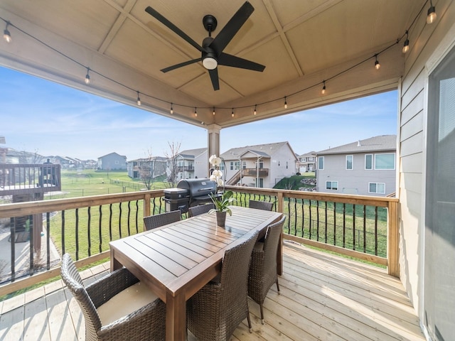 deck featuring area for grilling, a yard, a residential view, ceiling fan, and outdoor dining area