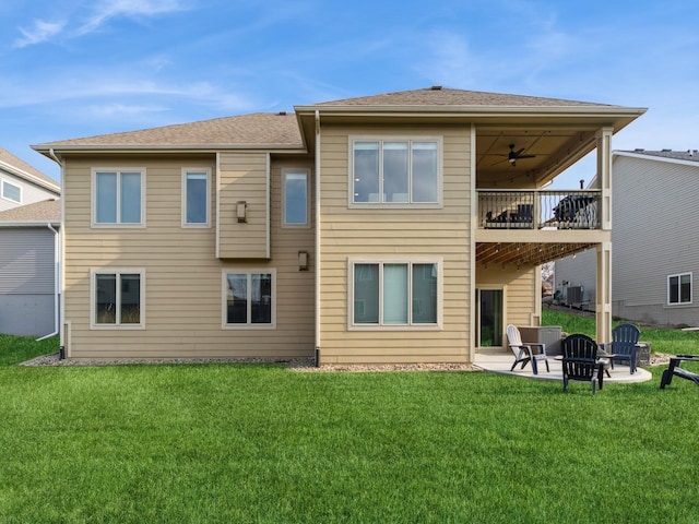 rear view of house featuring a balcony, a lawn, a ceiling fan, cooling unit, and a patio